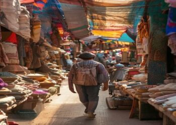 Traveler walking through a colorful local market with handmade textiles and warm afternoon light