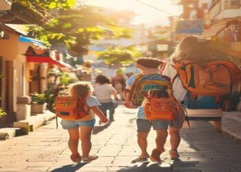 Family walking together through a sunny travel destination with backpacks and relaxed smiles