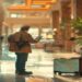 Traveler checking a city map and phone in a bright hotel lobby before going out